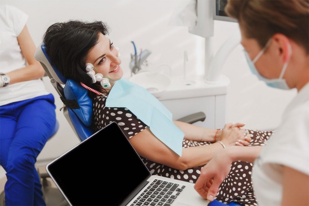 A patient wearing K7 jaw-tracking sensors during a bite examination